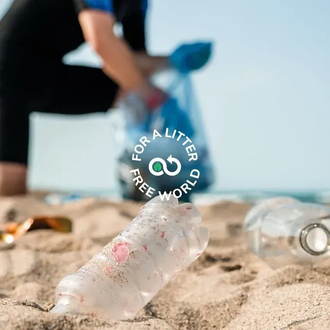 Volunteer cleaning litter on a beach with a plastic bottle in the sand, suited to NGO cleanup tracking