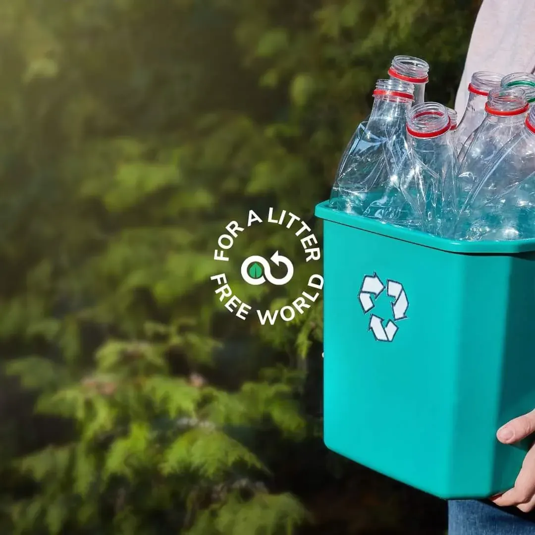 Person holding a recycling bin with plastic bottles outdoors Person holding a recycling bin with plastic bottles outdoors