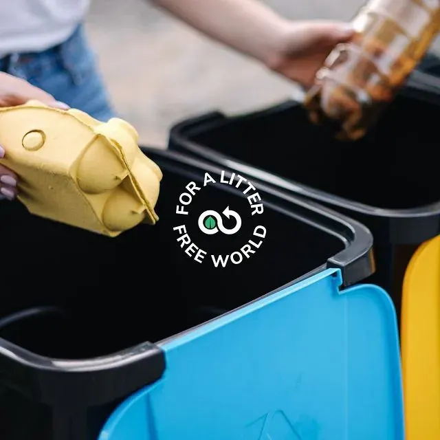 Person disposing waste into a recycling bin, relevant to collection efforts in Dubai